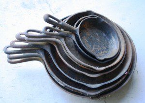 This stack of garage sale cast iron skillets can be restored to usefulness with a little work.