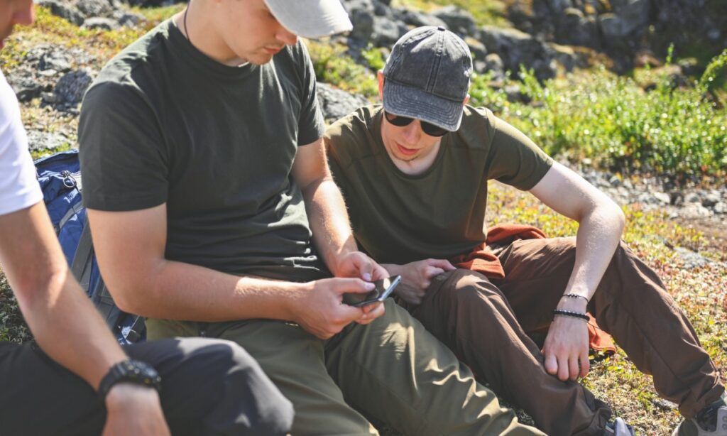 groups of hikers looking at cellphone device