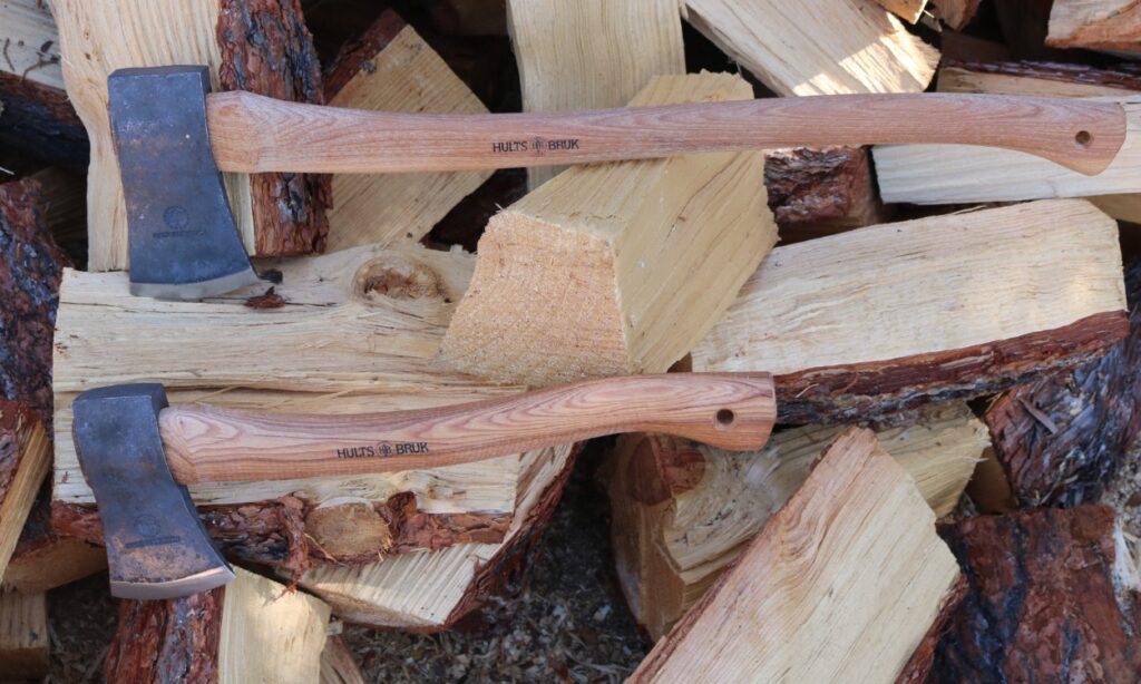 2 Hults Bruk Axes laying on a pile of chopped wood