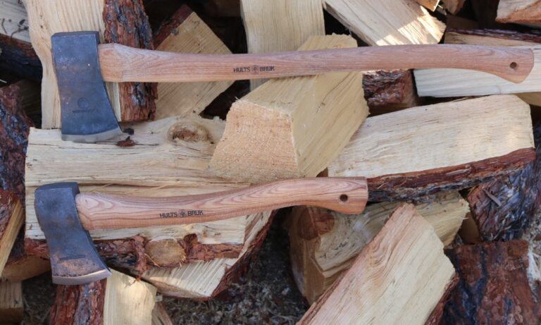 2 Hults Bruk Axes laying on a pile of chopped wood